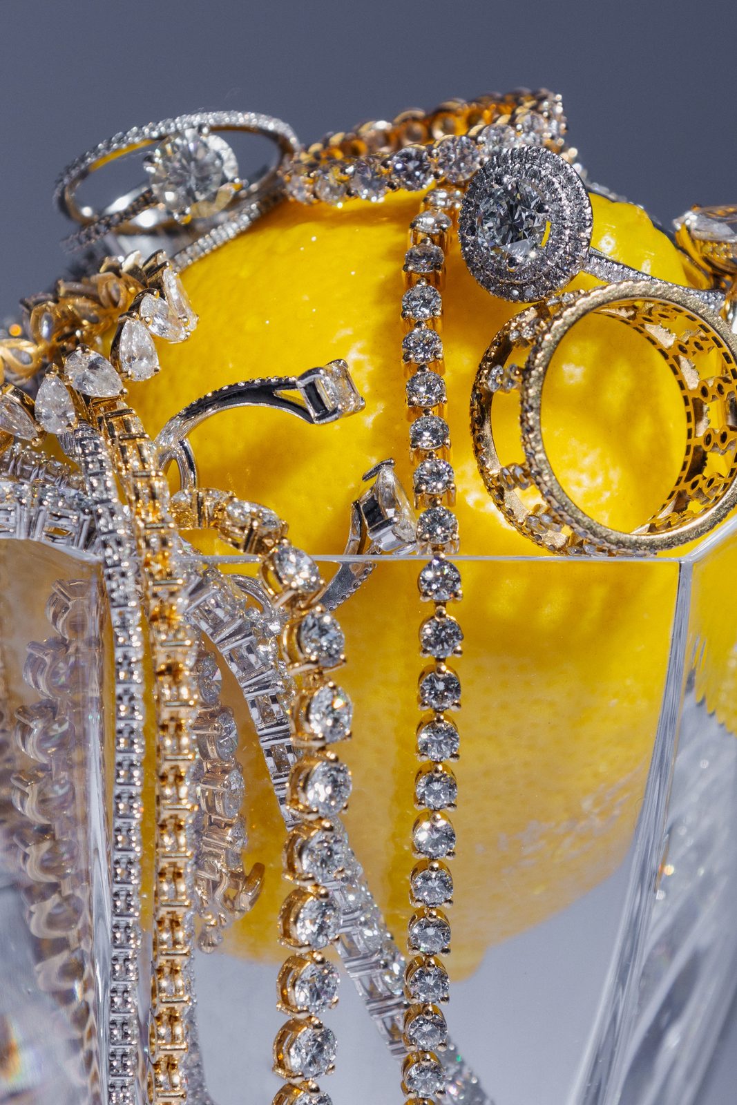 Bagues et bracelets sertis de diamants posés sur un citron jaune