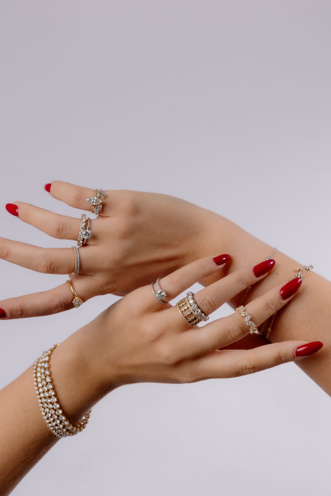 Deux mains aux doigts écartés portant plusieurs bagues diamants et un bracelet rivière
